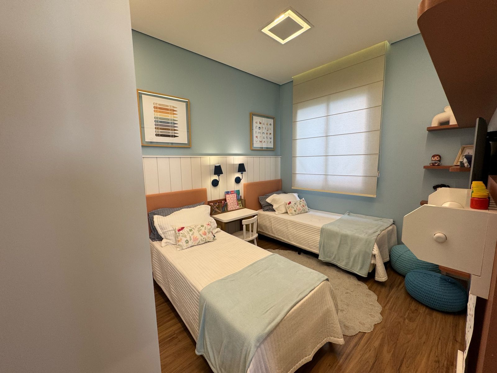 Dormitório infantil do decorado com duas camas de solteiro, prateleiras e escrivaninha